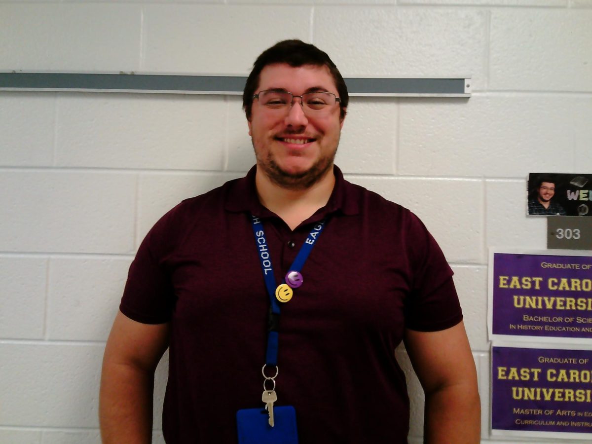 Landstown High School social studies teacher Mr. Zira poses for a photo outside his classroom.